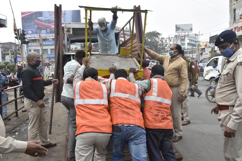 Police taking away illegall stalls during anti-encroachment drive in Ranchi