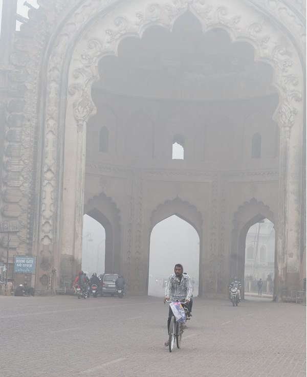 A man cycles in a fog covered morning in Lucknow