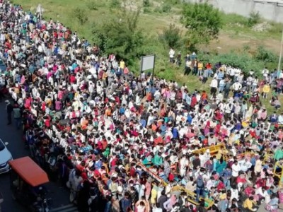 Amid COVID-19 lockdown, thousands of migrant workers gather at Delhi bus station to return home