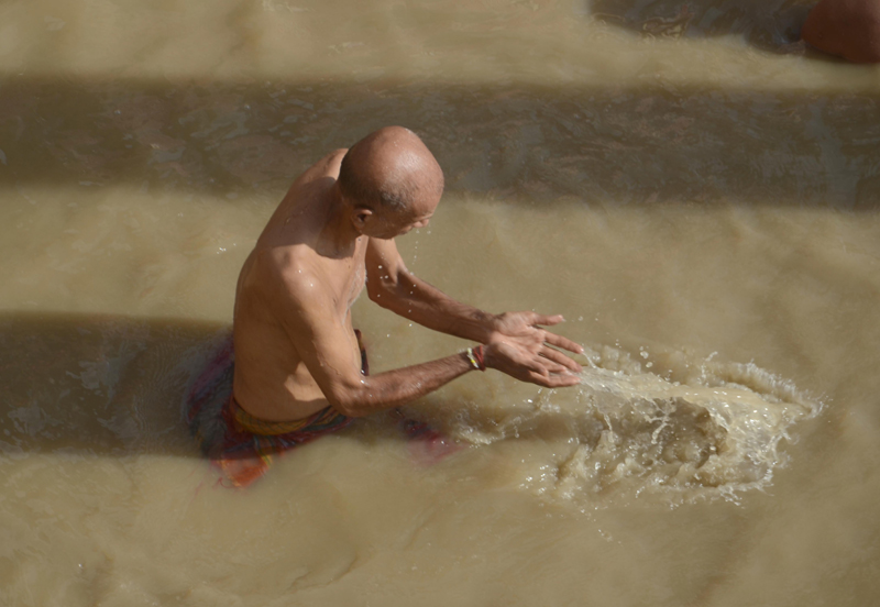 Varanasi: A devotee offering prayer in holy river Ganga
