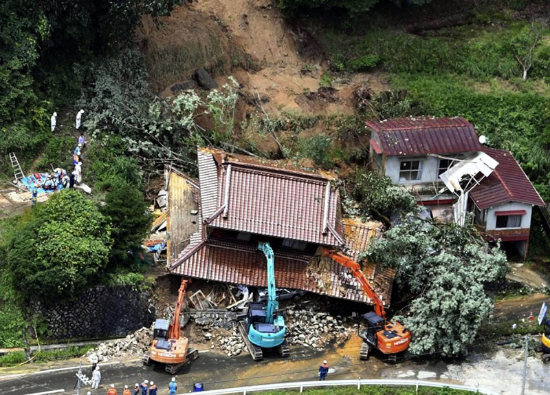 Japan: Excavators removing house damaged by a mudslide