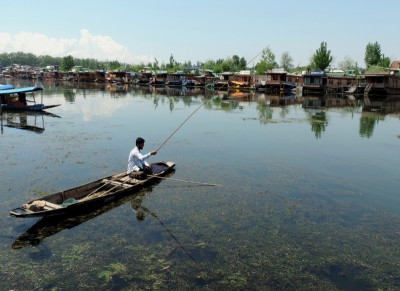 Jammu and Kashmir: Boat man fishing in Dal Lake