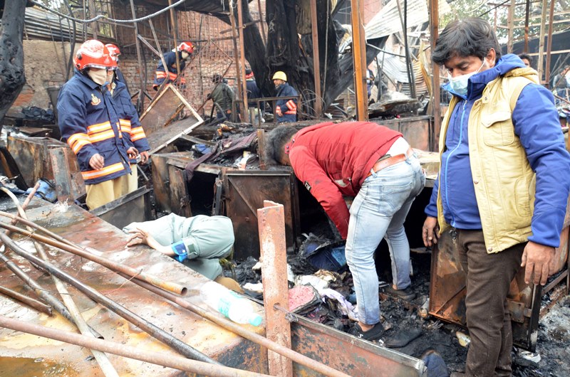 Firefighters extinguishing fire at Delhi's Lajpat Rai market